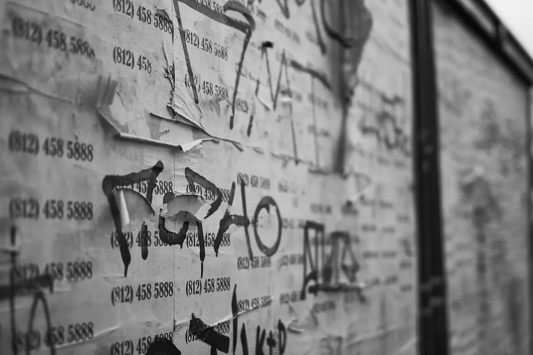 Torn posters and graffiti on a weathered wall