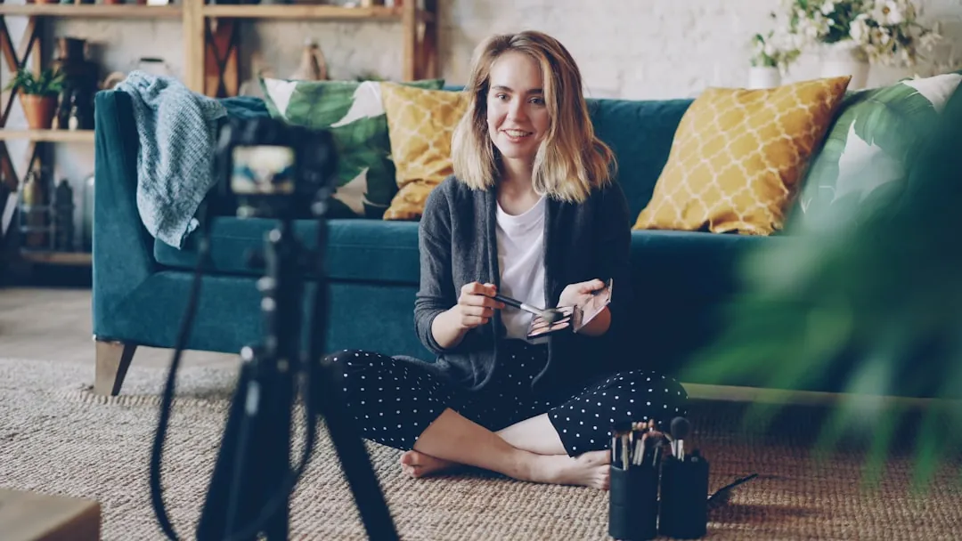 Woman recording video with camera in living room