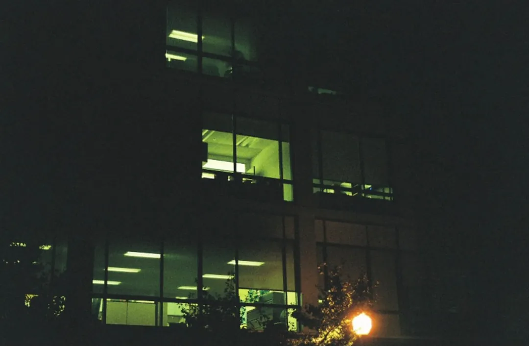 a building lit up at night with a street light in front of it