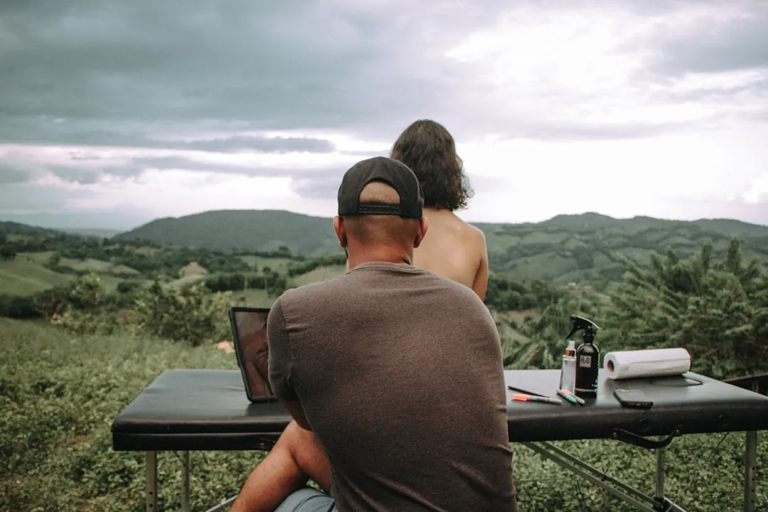 a man and a woman sitting at a table with a laptop