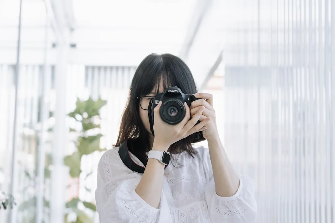 woman in white shirt holding black camera